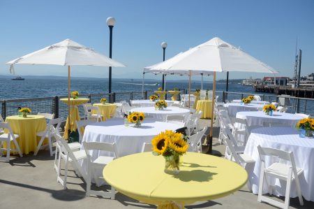 Company-picnic-on-pier-in-Seattle-with-sunflowers-and-white-umbrellas
