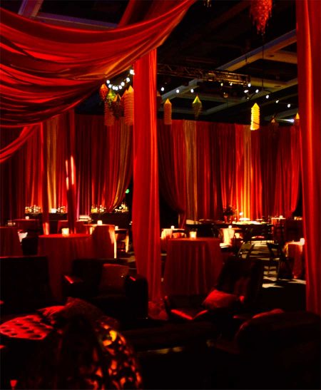 Red-draped-room-with-cocktail-tables-and-lights-for-corporate-gala